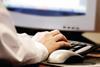 hand typing on computer keyboard with mouse in view