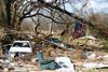 storm damaged car and household rubble