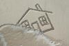 House drawn in the sand being washed away by the tide