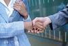 Business women shake hands suits