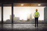 construction worker looking out high rise