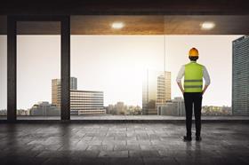 construction worker looking out high rise