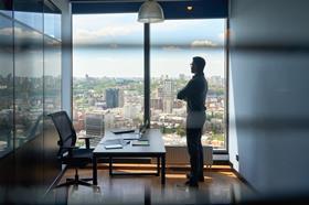 man looking out of office window_getty