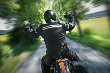 Biker in leathers on a country lane