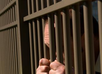 prisoner's hands grippingt cell bars