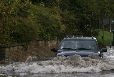 car in water on flooded road