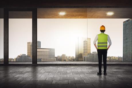 construction worker looking out high rise
